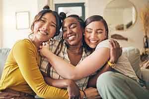 Group of friends smiling while hugging on couch