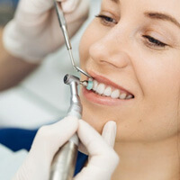 a patient undergoing a depp cleaning from her dentist