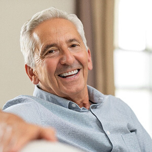 man smiling while sitting on couch