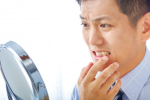 Man looking at his dental crown in mirror